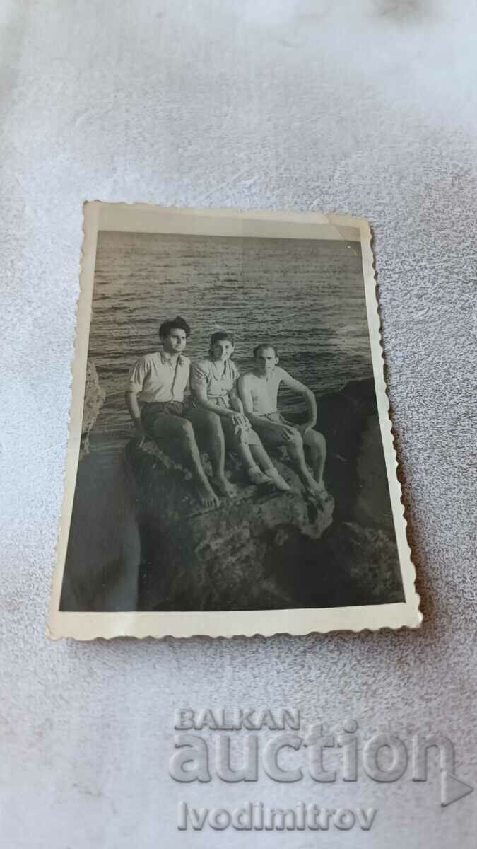 Εικόνα Δύο άντρες και ένα κορίτσι σε έναν βράχο πάνω από τη θάλασσα