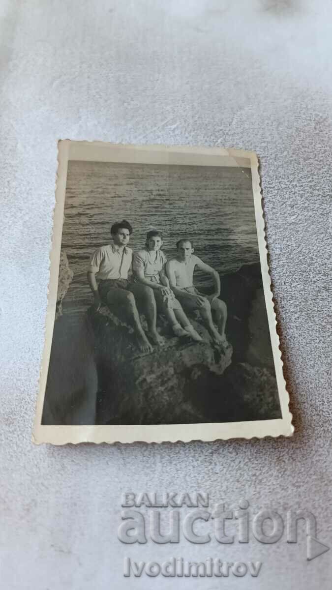 Picture Two men and a girl on a cliff above the sea