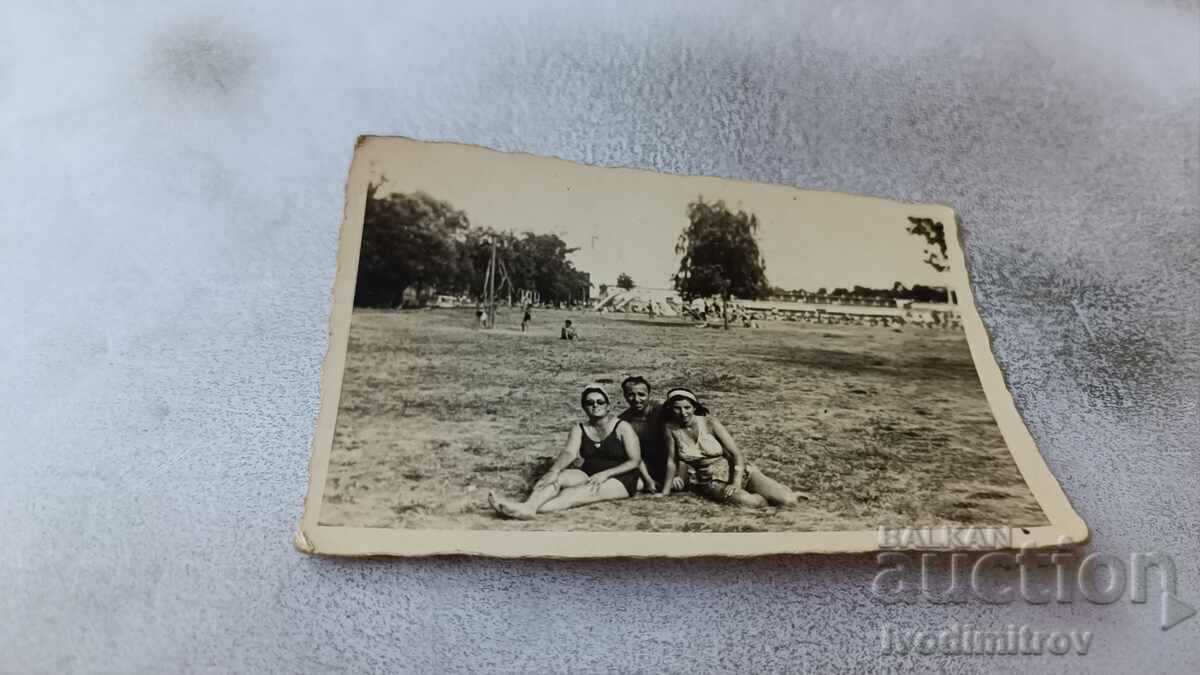 Photo A man and two women in retro swimsuits on the lawn