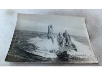 Foto Trei bărbați în costume de baie pe o stâncă în mare