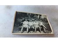 Φωτογραφία Knyazevo Τέσσερις νεαροί άνδρες κάθονται σε ένα παγκάκι στο πάρκο