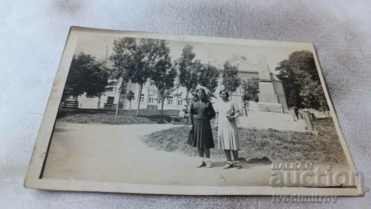 Photo Two young girls in front of a war memorial