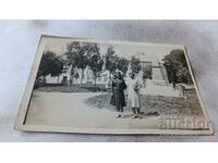 Fotografie Două fete tinere în fața unui memorial de război