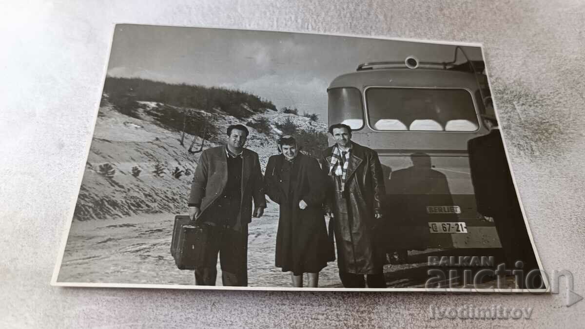 Photo Two men and a woman next to a bus with registration number Sf 67-21