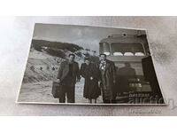 Photo Two men and a woman next to a bus with registration number Sf 67-21