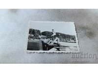 Снимка Младо момиче по бански седнало на парапет на мост