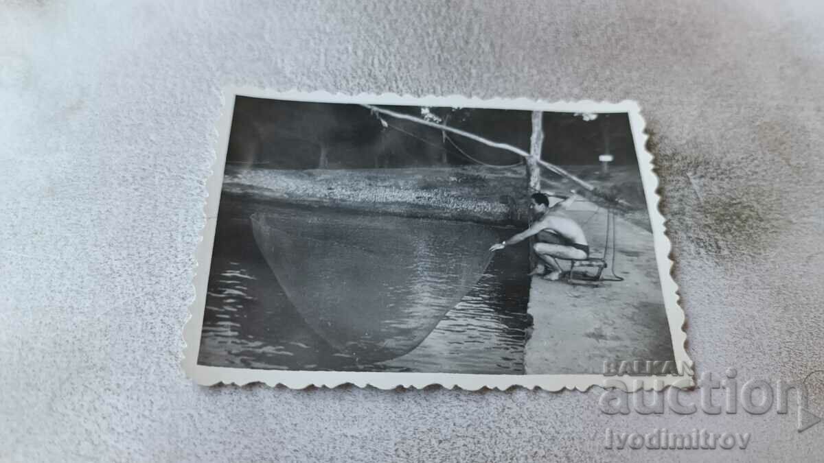 Снимка Мъж по бански ловящ риба