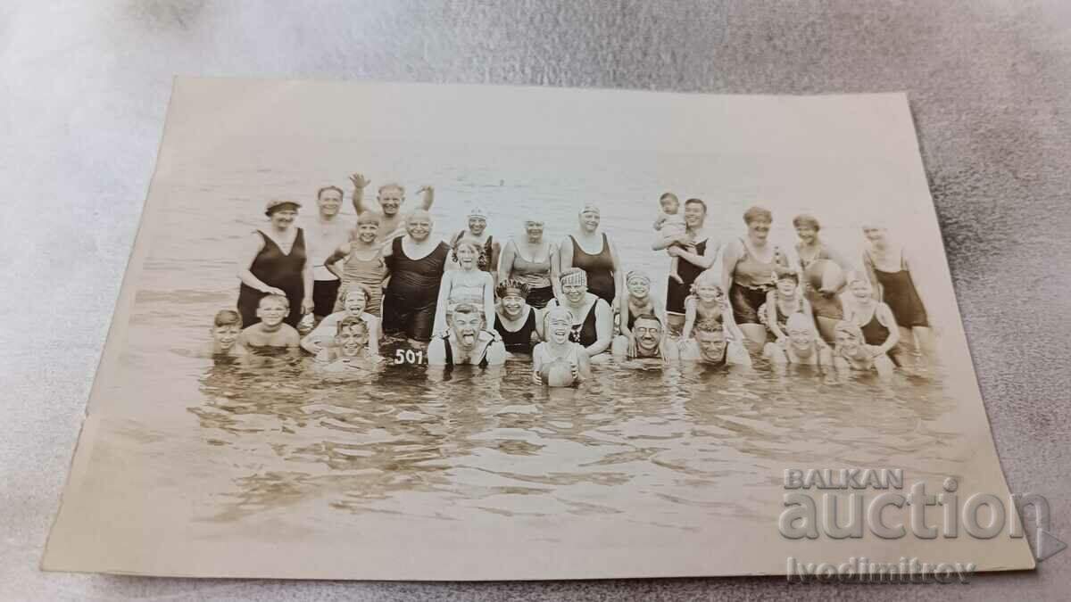 Photo Men, women and children in vintage swimwear on the beach