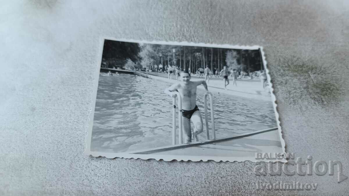 Photo A man in a swimsuit exiting a swimming pool