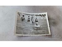 Φωτογραφία Γυναίκες αγόρι και κορίτσια στη θάλασσα
