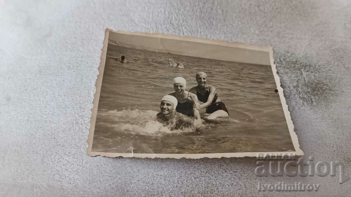 Снимка Мъж и две млади момичета на брега на морето