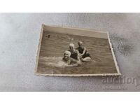 Снимка Мъж и две млади момичета на брега на морето