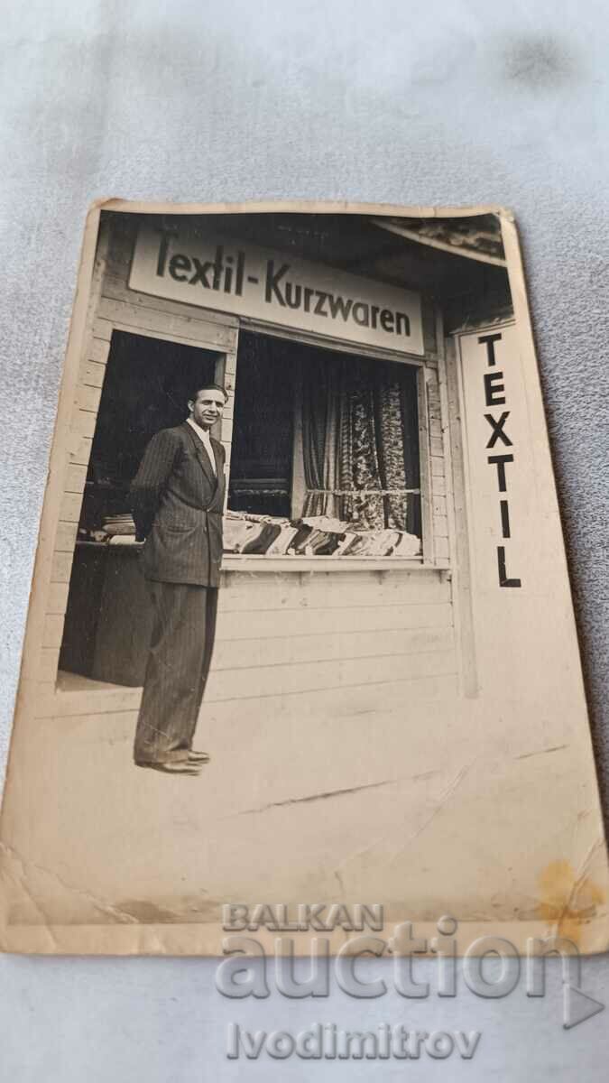Fotografie Un bărbat în fața unui magazin de textile