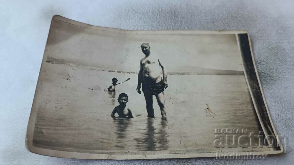 Fotografie Un bărbat și doi băieți pe plajă