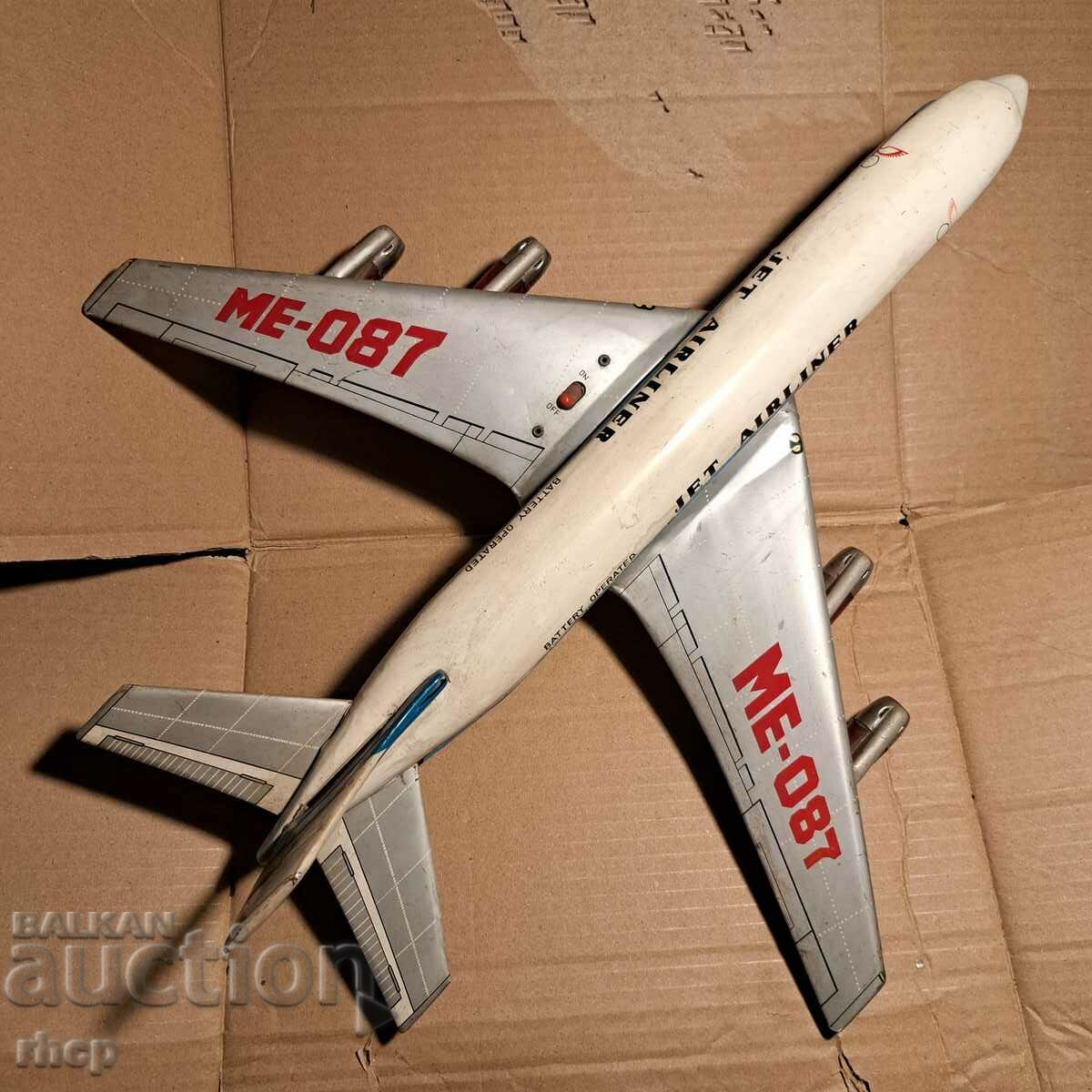 Un avion uriaș de jucărie din tablă