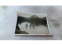 Foto Trei bărbați în râu