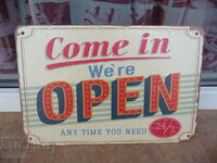 Metal sign saying Open 24/7 anytime when