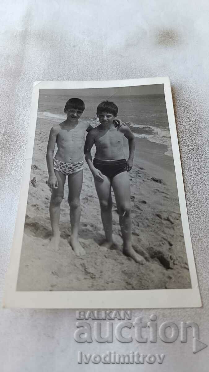 Foto Doi băieți în costume de baie pe plajă