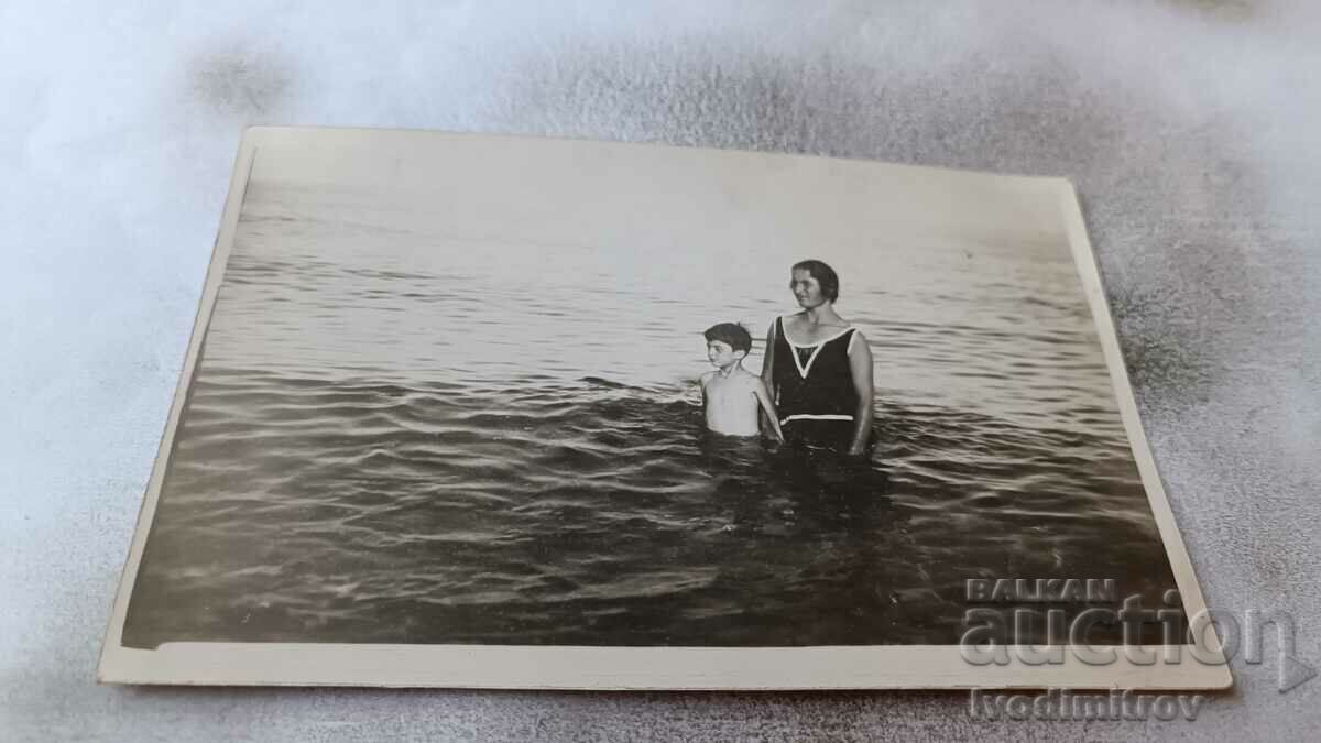 Foto Băiat și femeie în costum de baie retro în mare