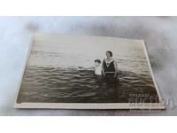 Photo Boy and woman in vintage swimsuit in the sea