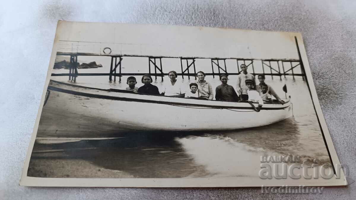 Photo Women and children in a wooden boat for walks on the shore