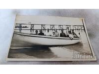 Снимка Жени и деца в дървена лодка за разходки на брега