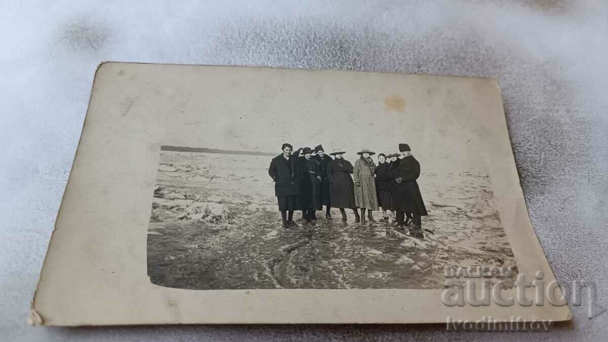 Photo Men and women in winter coats on the frozen sea