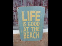 Inscripție pe plăcuță metalică Viața la plajă este grozavă de groapă