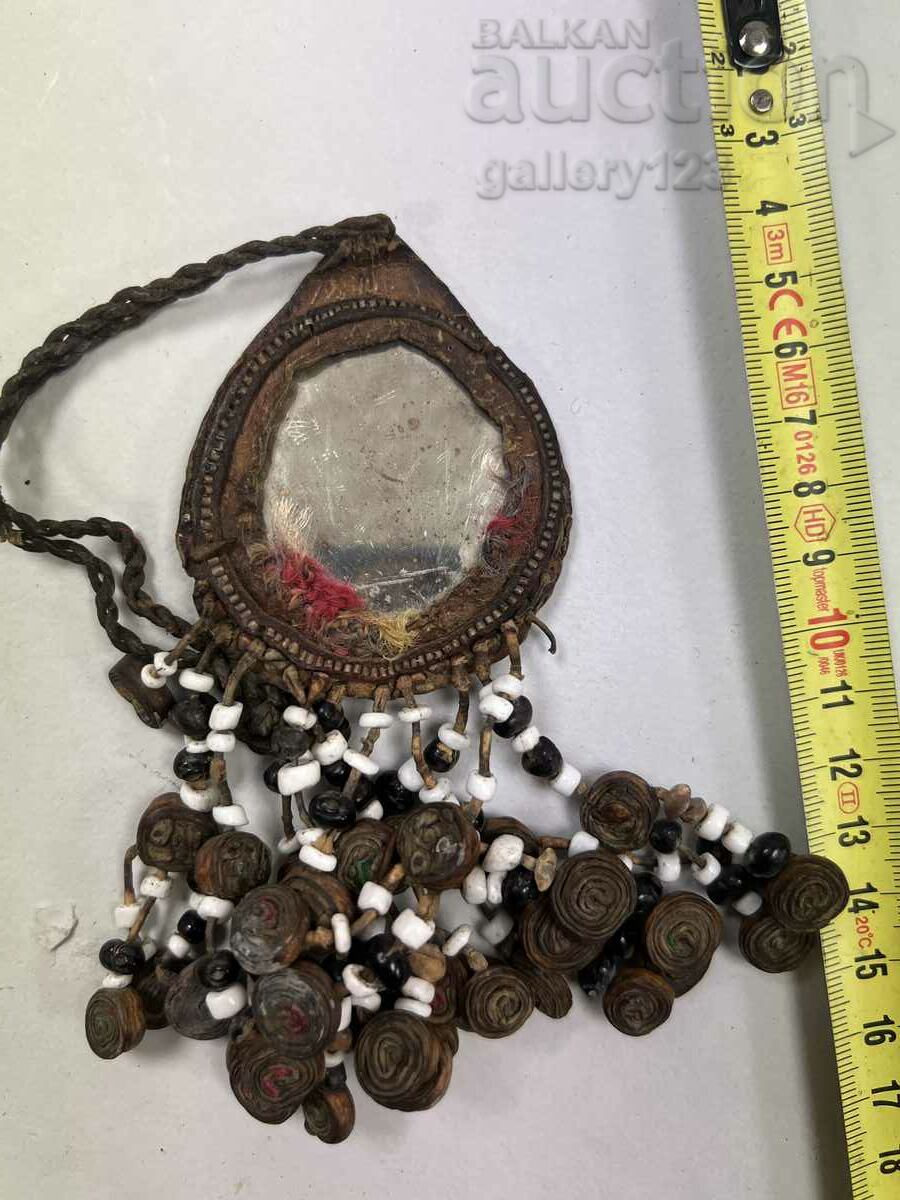 A Tibetan pendant flickers across a mirror