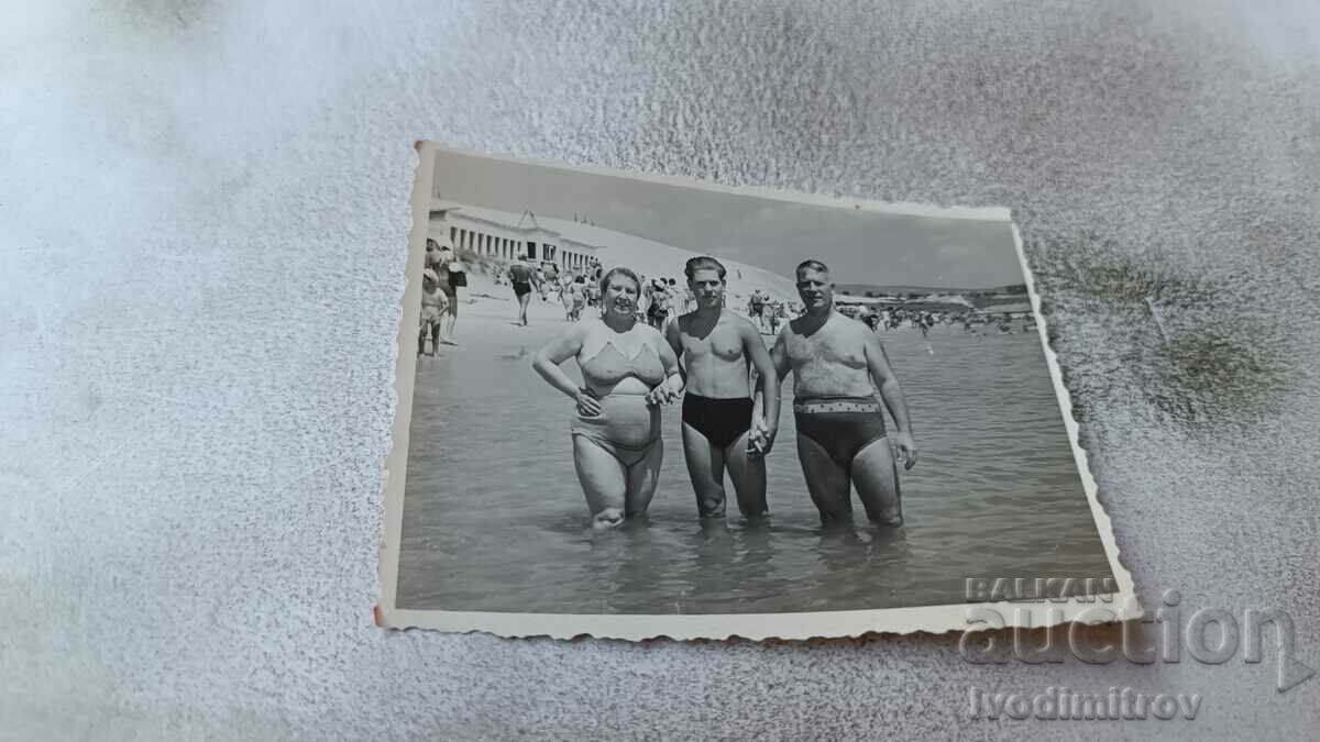 Foto Doi bărbați și o femeie pe plajă