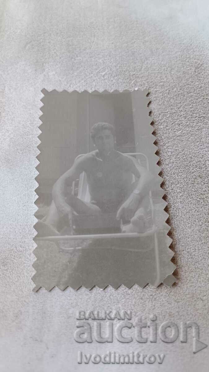 Fotografie Tânăr în costum de baie pe un pat de camping