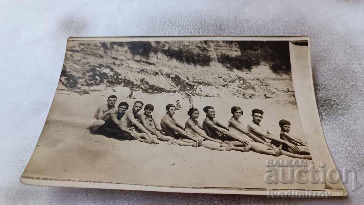 Photo Young men and women sitting on a train on the beach
