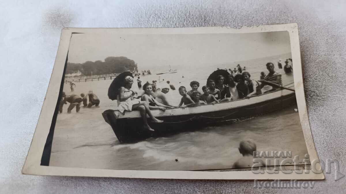 Foto Fete și băieți pe o barcă pe malul mării
