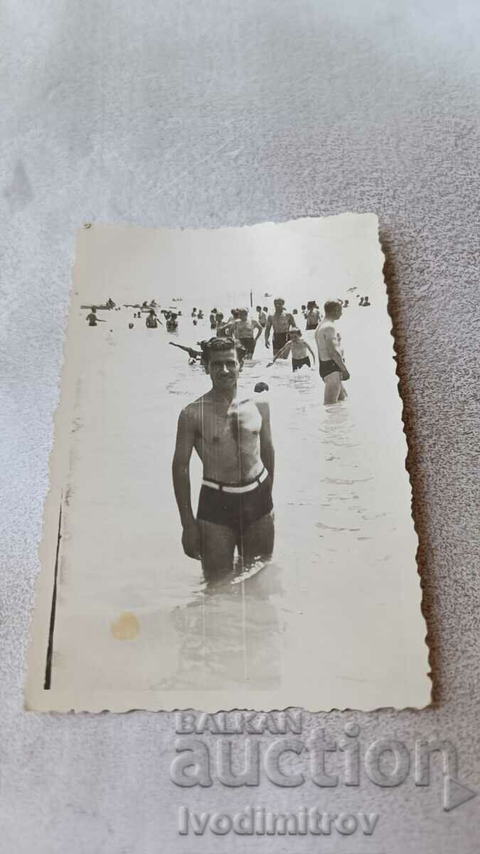 Photo A man in a retro swimsuit on the beach