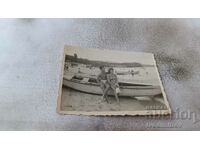 Снимка Млад мъж и млада жена до дървена лодка на брега