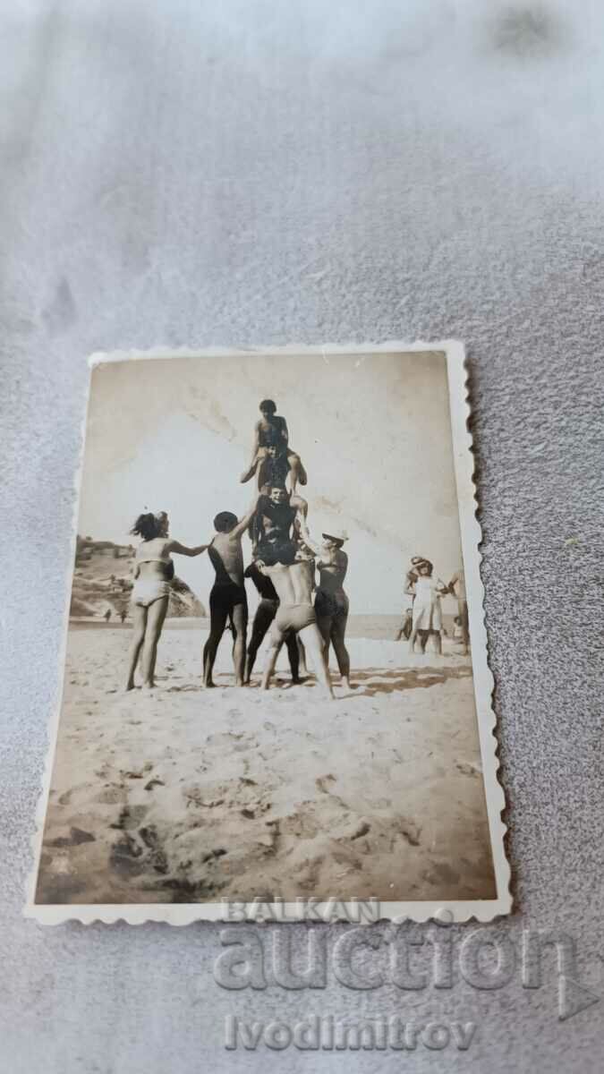 Снимка Младежи и девойки правят пирамида на плажа