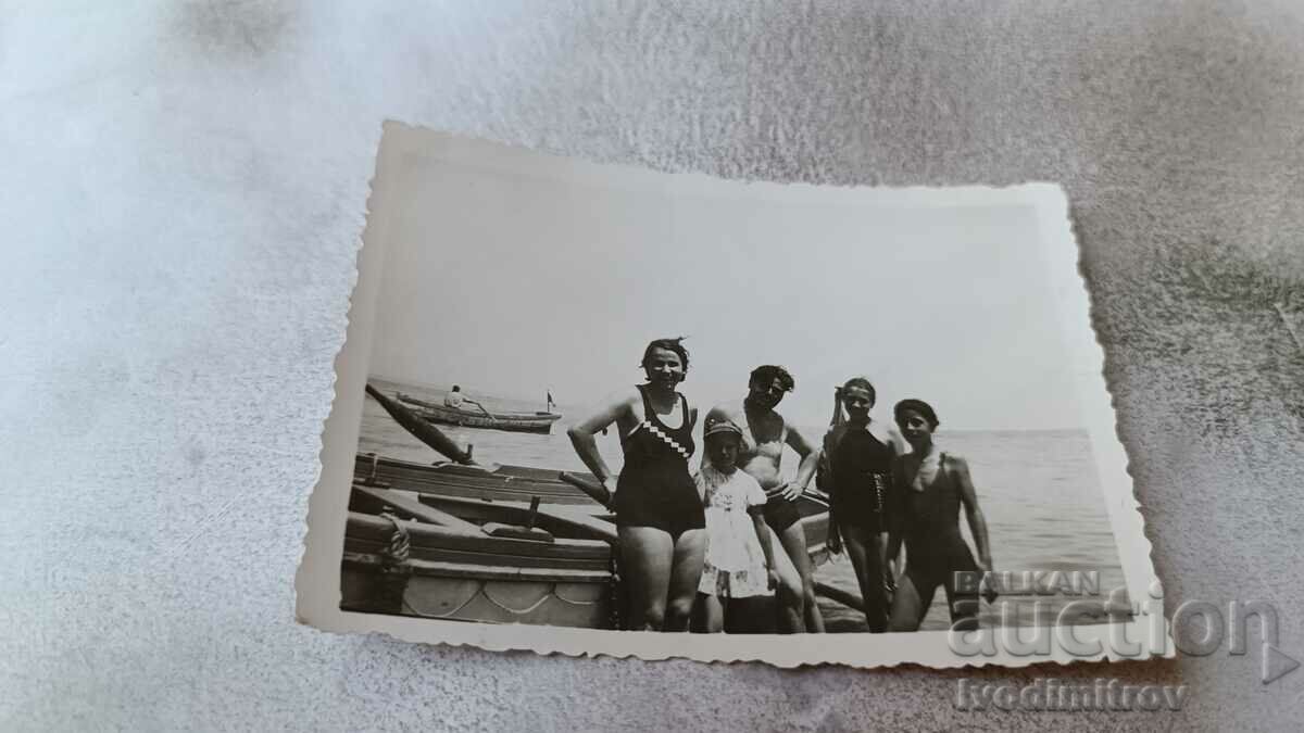 Снимка Мъж жена и млади момичета до лодка на брега