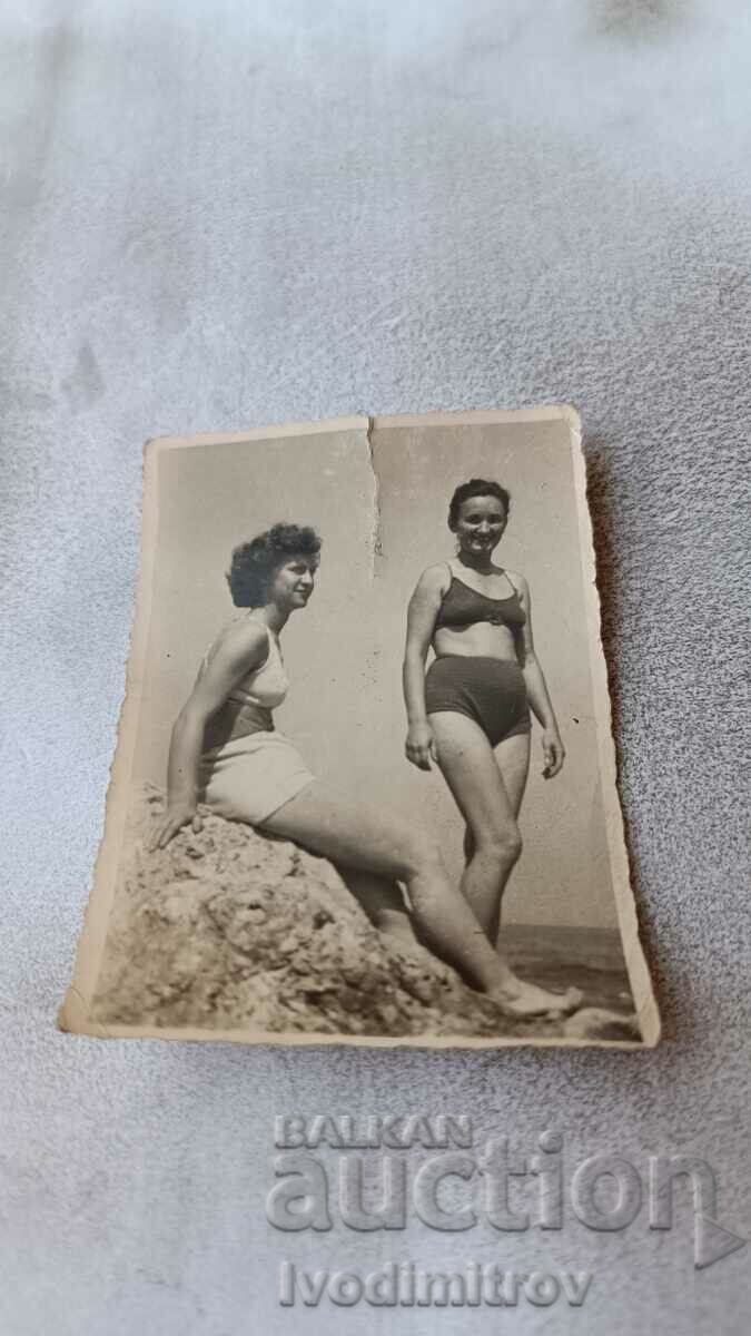 Fotografie Două tinere în costume de baie pe o stâncă deasupra mării