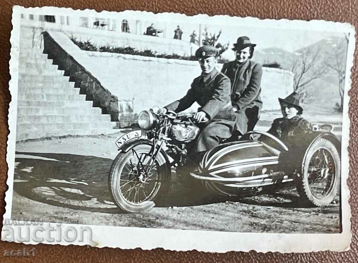 Ένας στρατιώτης σε μια μοτοσικλέτα με ένα καλάθι και δύο κυρίες