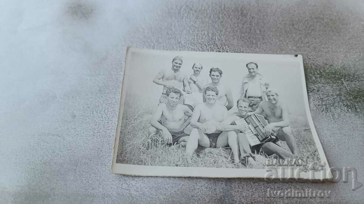 Снимка Мъже голи до кръста с акордеон на тревата