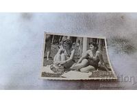 Photo Two young girls in vintage swimsuits sitting on the grass