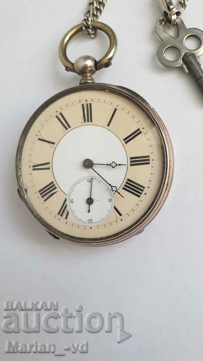 Old silver pocket watch with key