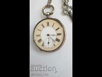 Old silver pocket watch with key