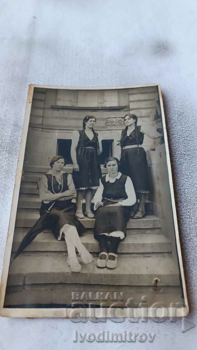 Снимка Четири млади момичета в традиционно облекло на стълби