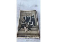 Photo Four young girls in traditional clothing on stairs