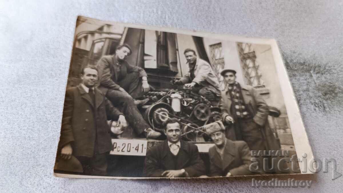 Ms. Ruse Men in front of a retro truck with registration number Rs 20-41