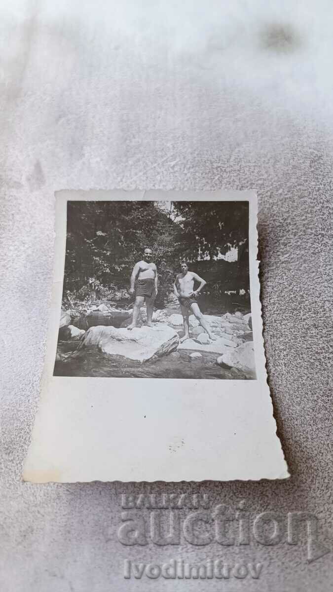 Photo Two men in swimsuits by the river