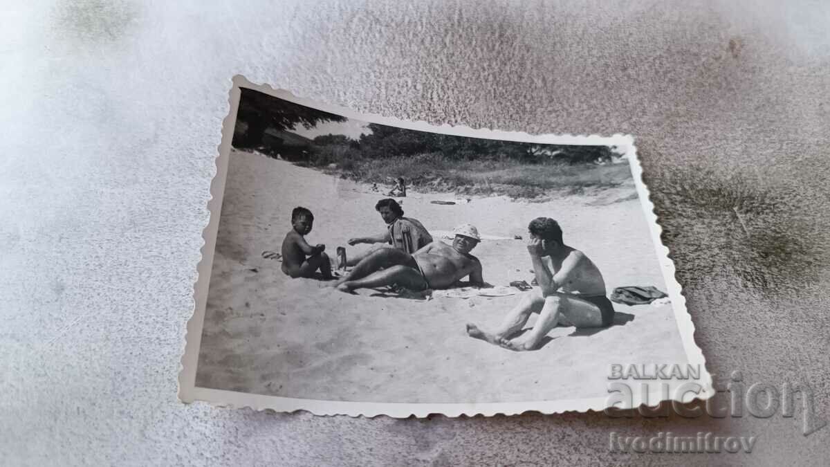 Photo Two men, a woman and a boy on the beach