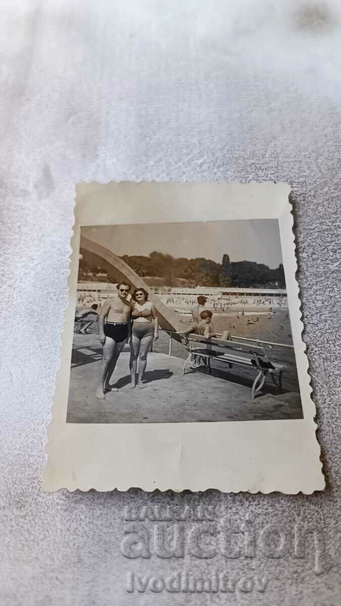 Photo Man and woman in swimsuits on the pier