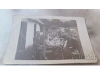 Photo Men women and children at a long wooden table